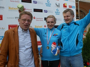 Glückwünsche an Joseline Oeser für ihren Sieg im Kriterium beim Prolog der 8. Ostthüringen Tour von Trainer Rolf Riemann und Thomas Richter, der das hellblaue Führungstrikot der eropräzisa GmbH überreichte.
